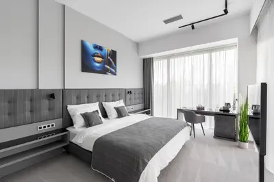 a bedroom with a bed and a desk and a television at Port Karolina Luxury Residence in Prague