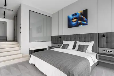 a bedroom with a large bed and a painting on the wall at Port Karolina Luxury Residence in Prague
