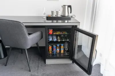 a desk with a mirror and a table with drinks at Port Karolina Luxury Residence in Prague
