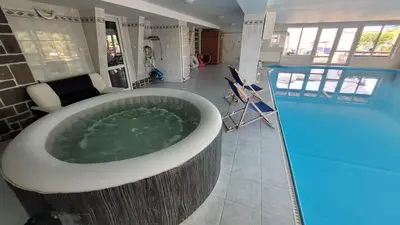 a bathroom with a tub and a swimming pool at Wellness Aqua House in Prague