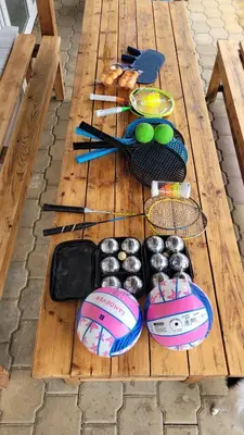 a wooden table with tennis rackets and balls on it at Wellness Aqua House in Prague