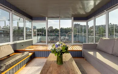 a living room with a vase of flowers on a table at Houseboat - best place in Prague in Prague