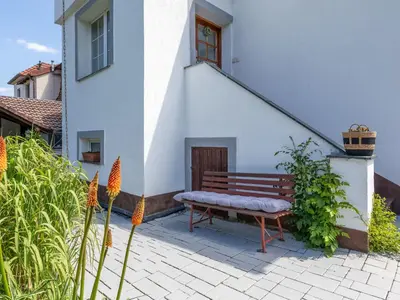 a bench sitting in front of a white building at Holiday Home Řevnice by Interhome in Řevnice
