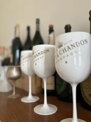 four wine glasses sitting on a table with bottles at Wenceslas square apartment 150 m2 in Prague