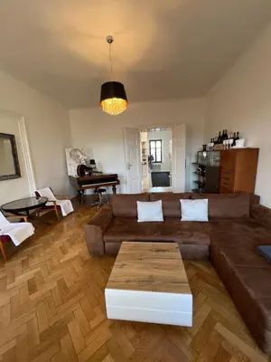 a living room with a brown couch and a table at Wenceslas square apartment 150 m2 in Prague
