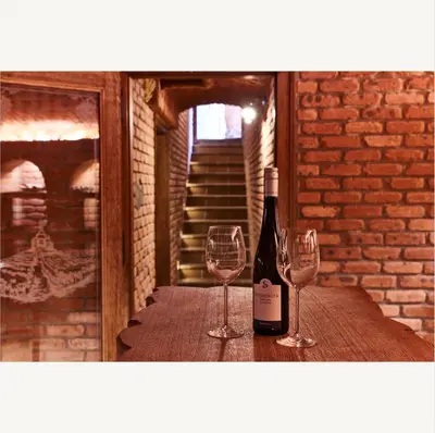 a bottle of wine and two wine glasses on a table at Apartmány Pekárna 1898 in Beroun