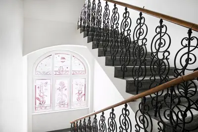 a staircase with wrought iron railings and a window at Numa Prague Flow in Prague