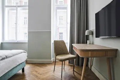 a hotel room with a desk and a bed and a table at Numa Prague Flow in Prague