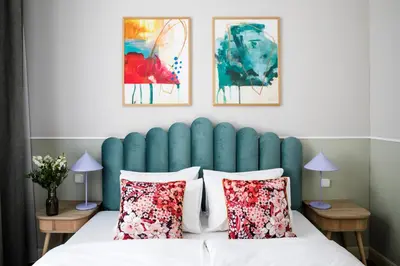 a bed with a blue padded headboard and pillows at Numa Prague Flow in Prague