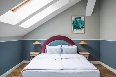 a bedroom with a white bed with blue walls at Numa Prague Flow in Prague