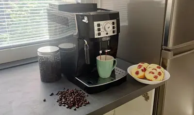 a coffee maker on a counter next to a bowl of cupcakes at King Size Sunny Home 19 minutes to Center in Prague
