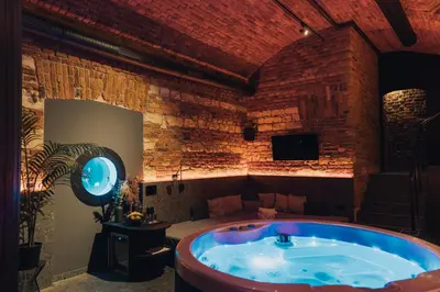 a hot tub in a room with a brick wall at SPA SPA Opletalova in Prague