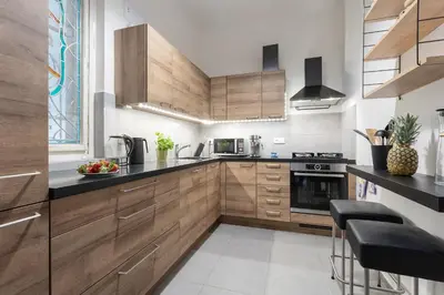 a kitchen with wooden cabinets and black counter tops at Bright and Spacious Attic Apartment in Prague