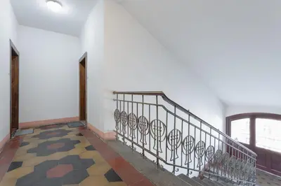 a hallway with a metal railing and a window at Bright and Spacious Attic Apartment in Prague