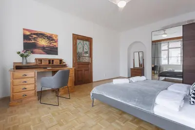 a bedroom with a bed and a desk with a chair at Bright and Spacious Attic Apartment in Prague