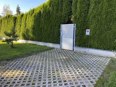 a door is open on a brick path next to a hedge at Luxusní apartmán v Praze Klánovicích na zahradě, 20 minut do centra Prahy in Šestajovice