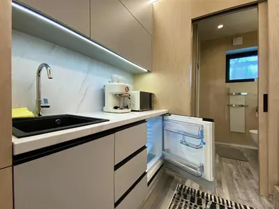 a kitchen with a sink and a microwave at Luxusní apartmán v Praze Klánovicích na zahradě, 20 minut do centra Prahy in Šestajovice