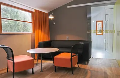 a living room with a couch and a table and chairs at Hotel Kokořín in Kokořín