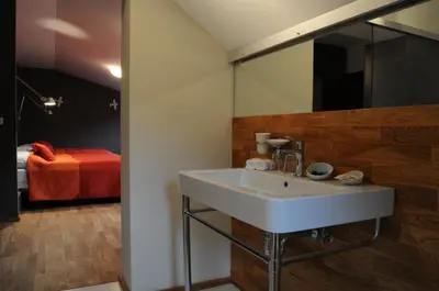a bathroom with a sink and a bed in the background at Hotel Kokořín in Kokořín