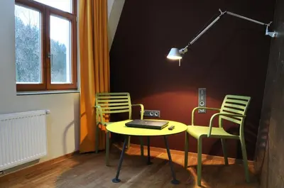a room with a table and two chairs and a laptop at Hotel Kokořín in Kokořín