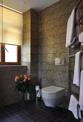 a bathroom with a toilet and a vase of flowers at Hotel Kokořín in Kokořín
