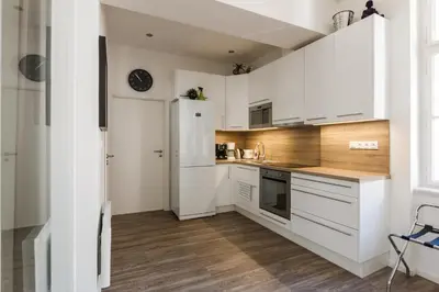 a kitchen with white cabinets and a white refrigerator at Prague Days - Open-plan Studio with AC near National Theatre in Prague