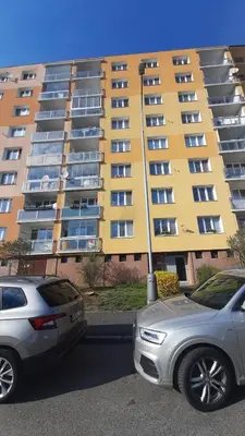 two cars parked in a parking lot in front of a building at Apartment Kamýk in Prague