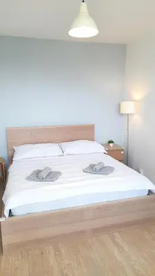 a white bed with two towels on top of it at Apartment Kamýk in Prague