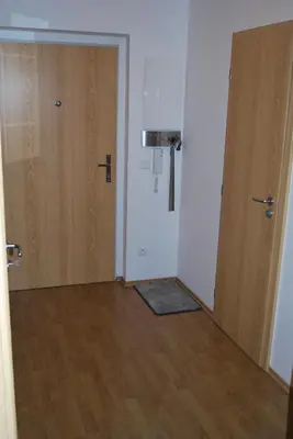 an empty room with two doors and a wooden floor at Chotěšovská Apartment with Parking Place in Prague