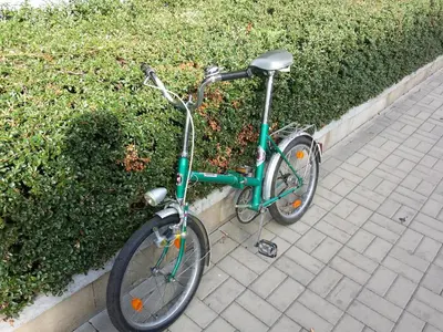 a green bike parked next to a hedge at Chotěšovská Apartment with Parking Place in Prague