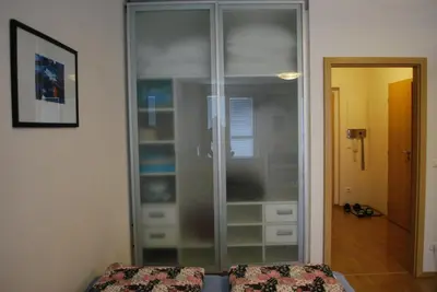 a glass cabinet in a room with a bed at Chotěšovská Apartment with Parking Place in Prague