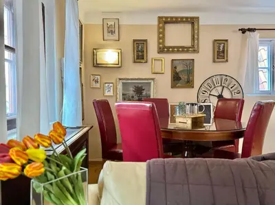 a dining room with a table and red chairs at 2-Floor Traditional Prague Apartment in Prague
