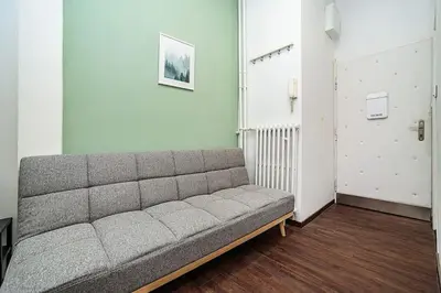 a gray couch in a room with a door at Cozy Old Town Stay - 1-bedroom apartment in Prague