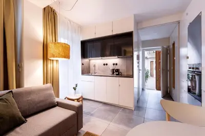 a living room with a couch and a kitchen at TurnKey I Studio by Amazing Park in Prague