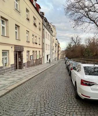 a cobblestone street with parked cars and buildings at TurnKey I Studio by Amazing Park in Prague
