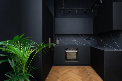 a kitchen sink with a gold faucet on a black counter at TurnKey I Premium Apartment in Prague