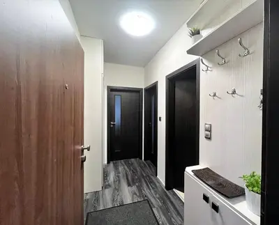 a bathroom with a wooden door and a hallway at British Quarter Apartments in Prague