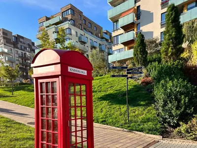 a red phone booth in front of a building at British Quarter Apartments in Prague
