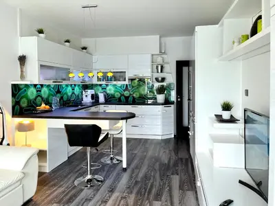 a kitchen with white cabinets and a black counter top at British Quarter Apartments in Prague