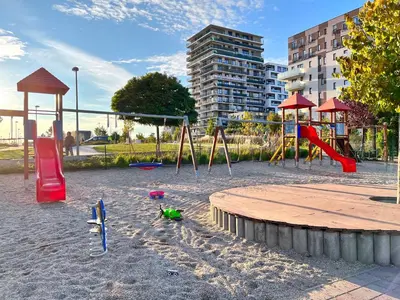 a playground with slides and a swing set in the sand at British Quarter Apartments in Prague