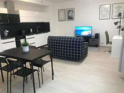 a kitchen and living room with a table and a couch at Apartmantplus02 in Prague
