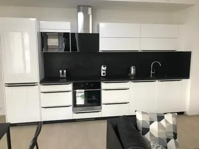 a kitchen with white cabinets and a black counter top at Apartmantplus02 in Prague