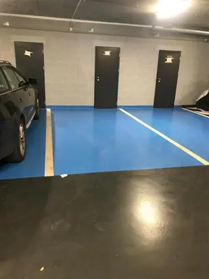 a parking garage with a blue floor and two doors at Apartmantplus02 in Prague