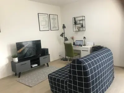 a living room with a couch and a desk and a television at Apartmantplus02 in Prague