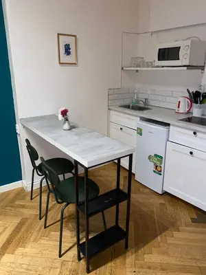a kitchen with a table and two chairs and a counter at Stylish studio apartment by Namesti Miru in Prague