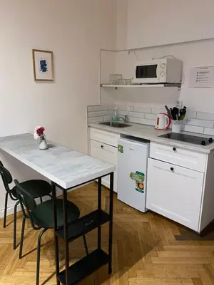 a kitchen with a table and a sink and a refrigerator at Stylish studio apartment by Namesti Miru in Prague