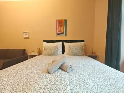 a bed with two pillows on it in a room at Spacious, Light Studio Apartment in Vinohrady in Prague
