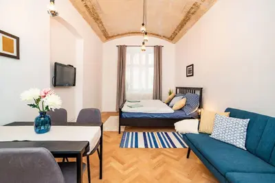 a living room with a couch and a table at Cosy, retro-styled flat in beautiful Zizkov in Prague