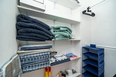 a walk in closet with blue towels on shelves at Cosy, retro-styled flat in beautiful Zizkov in Prague