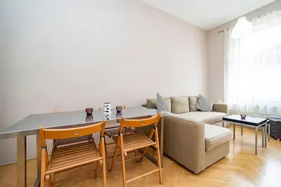 a living room with a couch and a table and chairs at Cozy and sunny apartment in uptown in Prague